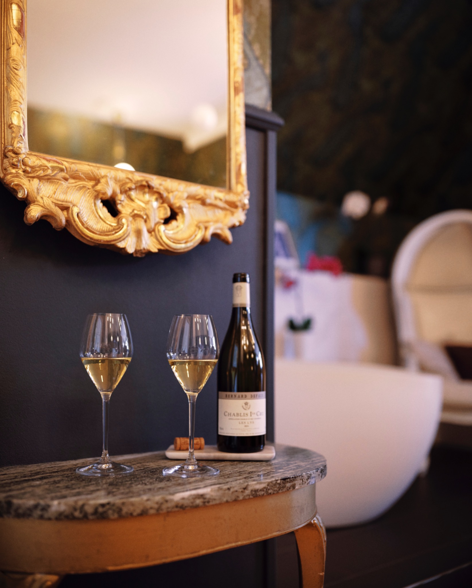 Two wine glasses beside a gold-framed mirror in a room at Grenna Hotell