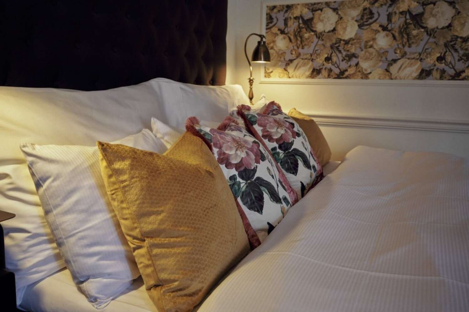 Närbild av dubbelsäng med blommiga kuddar